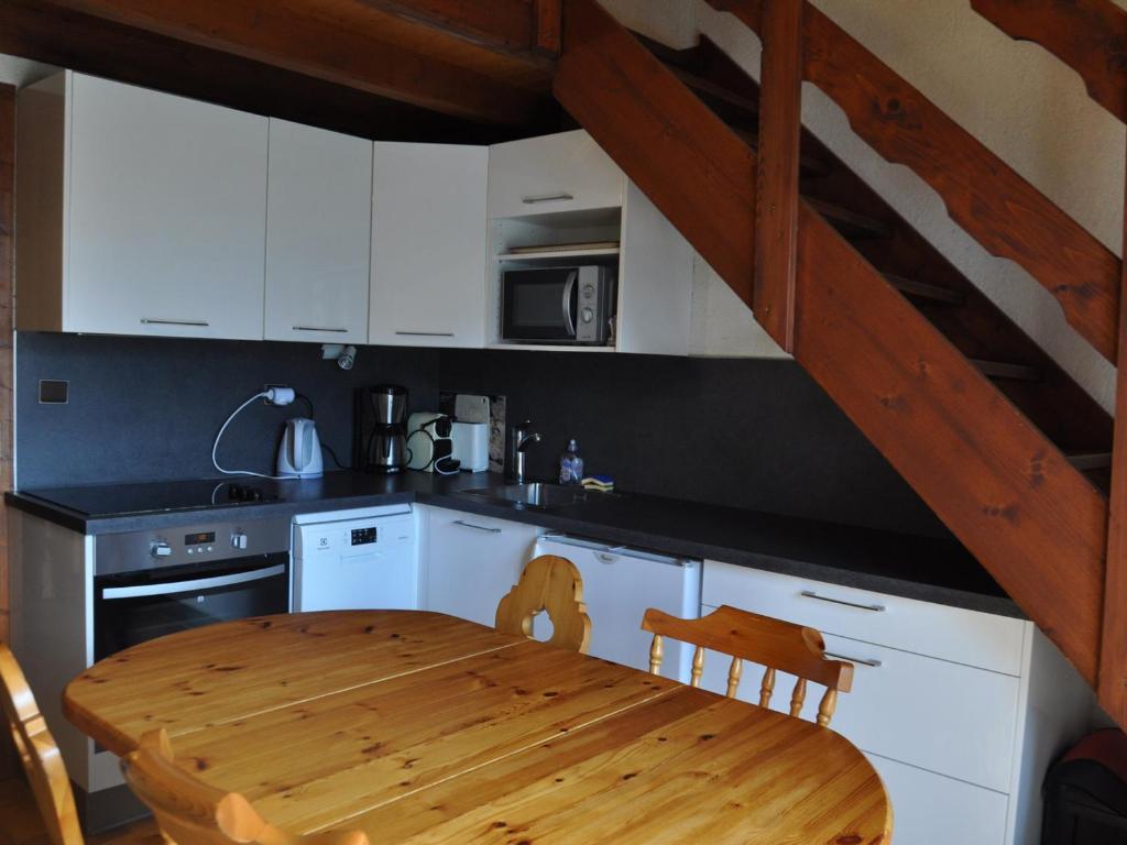 een keuken met een houten tafel en een keuken met witte kasten bij Appartement Châtel, 2 pièces, 5 personnes - FR-1-693-49 in Châtel