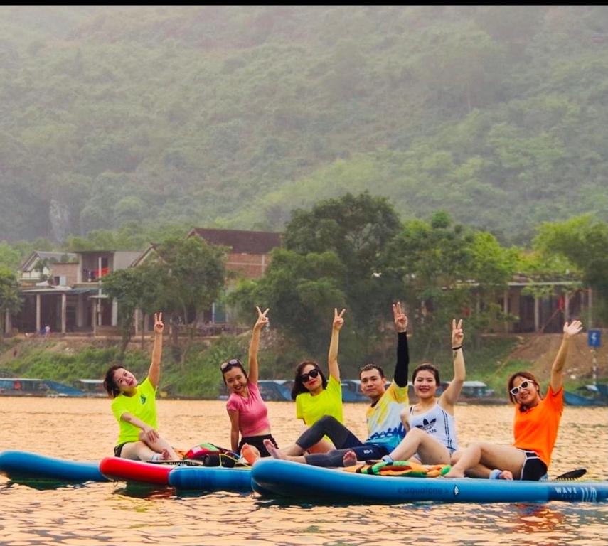 un grupo de personas sentadas en una balsa en el agua en Cornflower Homestay PHONG NHA, en Phong Nha