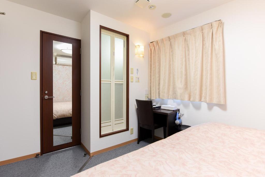 Postel nebo postele na pokoji v ubytování Otsuka Town Hotel