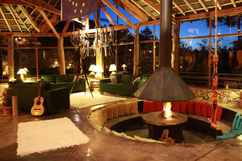 a living room with a couch and a table with a lamp at Alive Eco Hut Pousada in Monte Verde