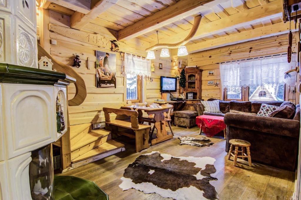 een woonkamer met houten wanden en een open haard in een huisje bij ZAKOPIANA Domek in Zakopane