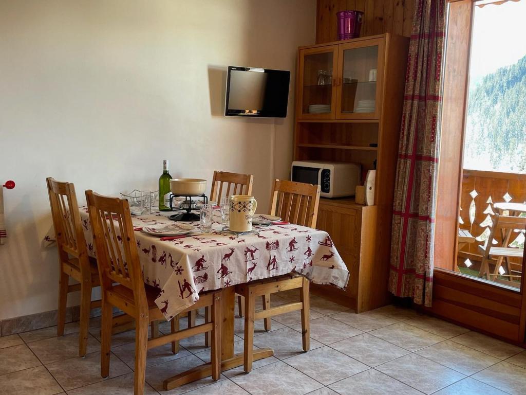 d'une salle à manger avec une table, des chaises et une fenêtre. dans l'établissement Confortable studio à 200m du centre avec Multi Pass été à 3€/jour, parking et balcon exposé Sud - FR-1-693-66, à Châtel