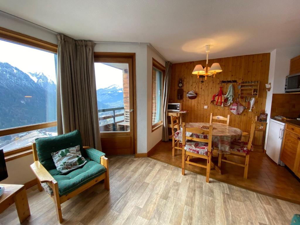 - un salon avec une table et une cuisine avec vue dans l'établissement Studio confortable près du centre avec balcon et parking - FR-1-693-74, à Châtel