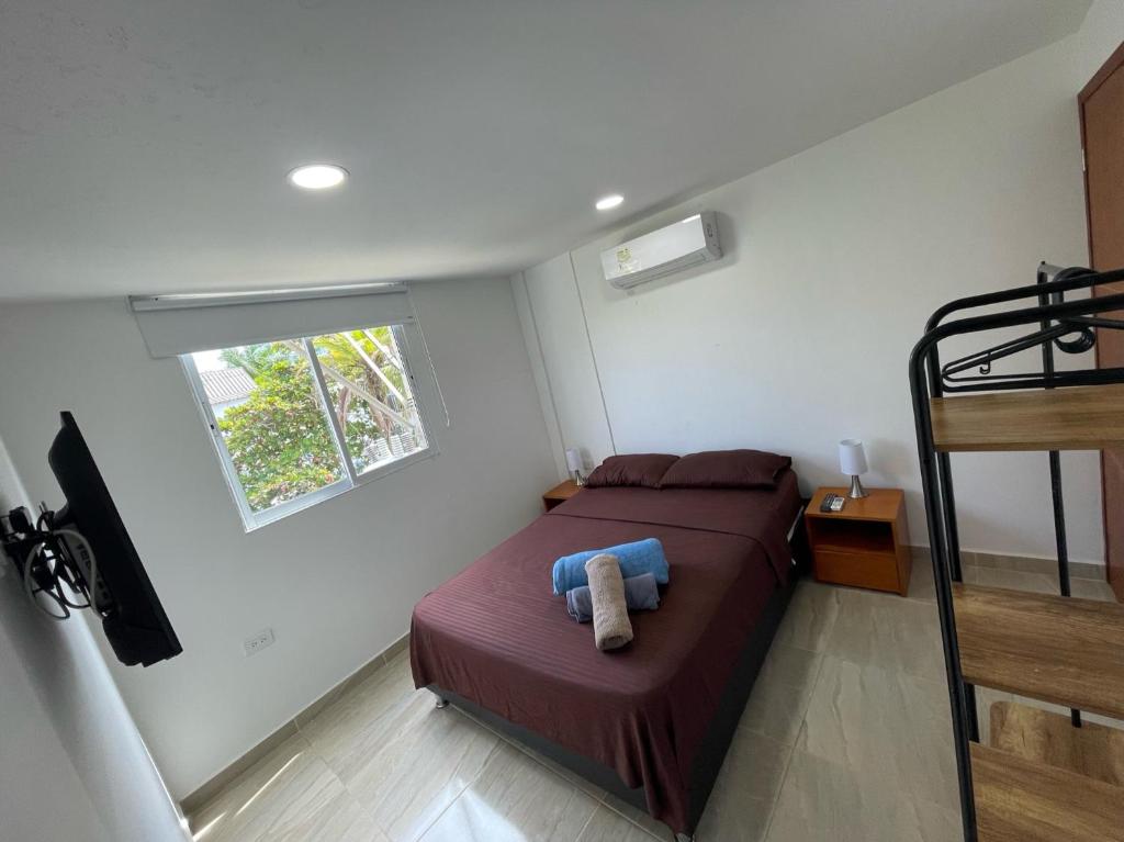 a small bedroom with a bed and a window at Hotel La Yarolina SAS in Cartagena de Indias