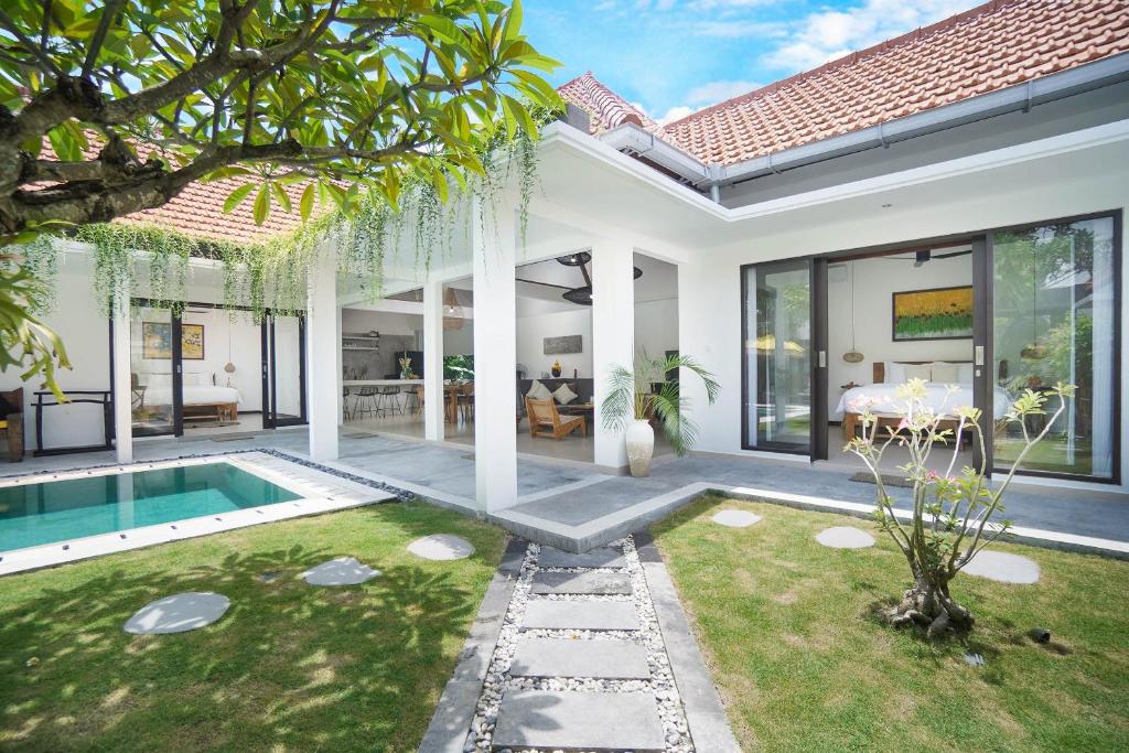 a villa with a swimming pool and a house at SunGlow Villa in Seminyak
