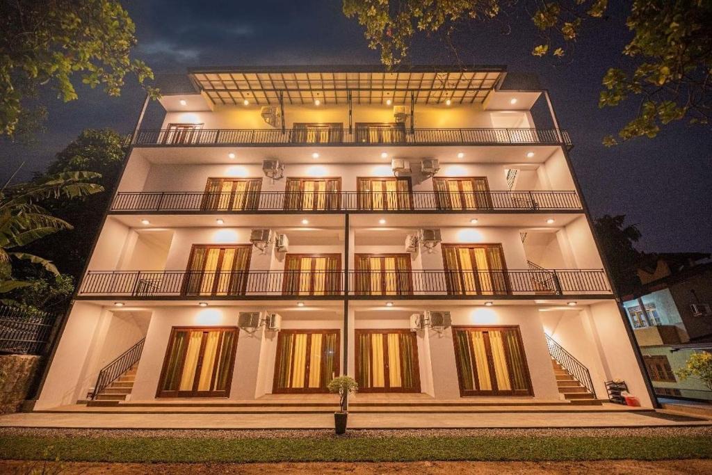 a large white building with a balcony at night at Y Villa Residencies in Galle