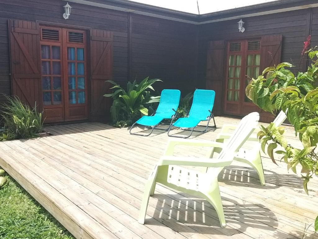 vier stoelen op een houten terras met een huis bij beautifull wooden house in Saint-Claude