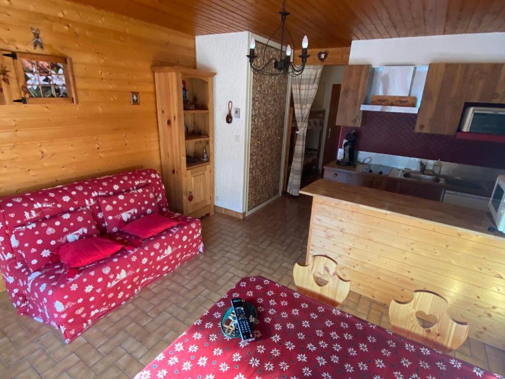 ein Wohnzimmer mit einem roten Sofa und einer Küche in der Unterkunft Studio La Chapelle-d'Abondance, 1 pièce, 4 personnes - FR-1-692-57 in La Chapelle-dʼAbondance