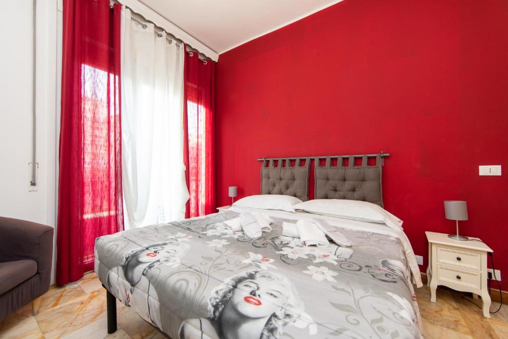 ローマにあるL'Imperiale RomaTrastevereの赤い壁のベッドルーム1室、ベッド1台が備わります。