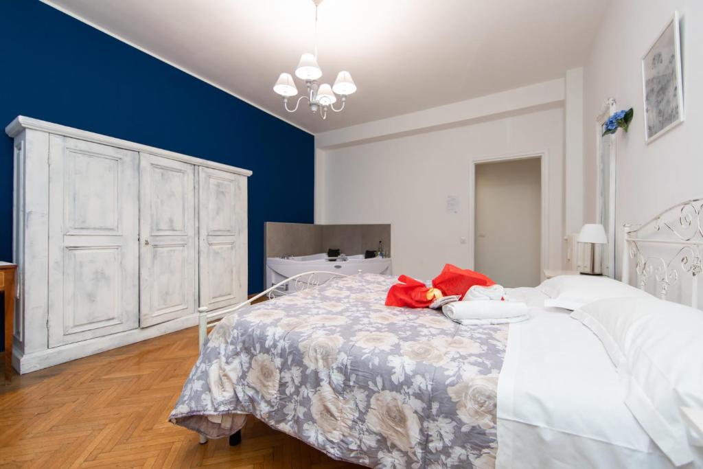 um quarto com uma cama branca e uma parede azul em L'Imperiale RomaTrastevere em Roma