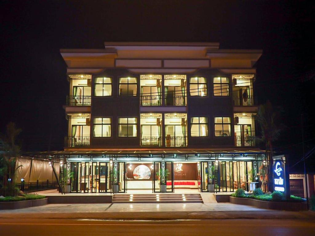 wysoki budynek z oświetleniem przed nim w nocy w obiekcie โรงแรมชลาลัย กระบี่ Chalalai Hotel Krabi w mieście Ban Nua Khlong