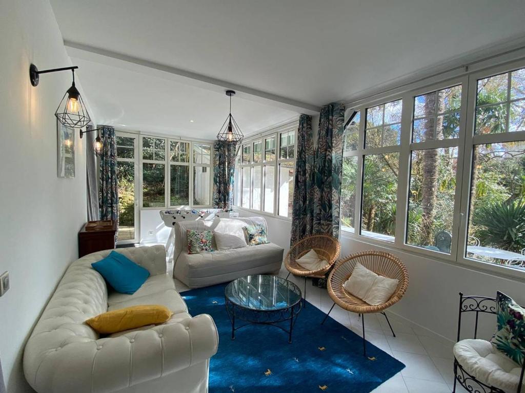 - un salon avec un canapé blanc et un tapis bleu dans l'établissement À 350 m de la plage, superbe T3 rénové avec terrasse et jardin, quartier calme, internet inclus - FR-1-433-92, à Arcachon