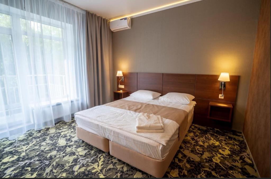 sypialnia z dużym łóżkiem i dużym oknem w obiekcie Family Resort Utes w mieście Czebarkul
