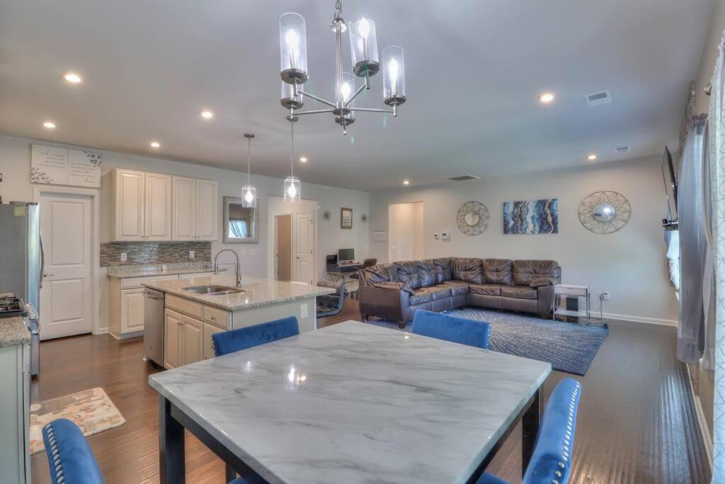 a kitchen and living room with a table and blue chairs at The Muirwood Retreat in Murfreesboro