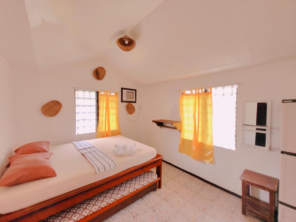 a bedroom with a bed and two windows at Patrick's on the Beach Resort in General Luna