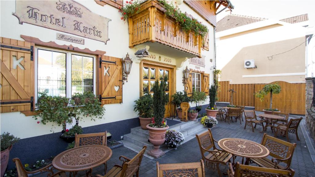 an outdoor patio with tables and chairs and a building at Hotel Karin in Budapest