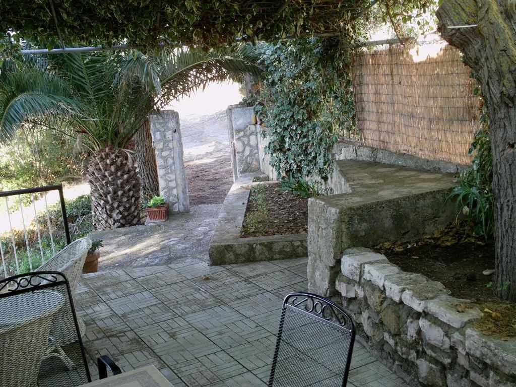 an outdoor patio with chairs and an arch with a view of the beach at Apartments Elena & Damir in Vis