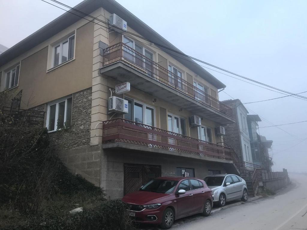 dos coches estacionados frente a un edificio en Vince Apartments, en Kruševo