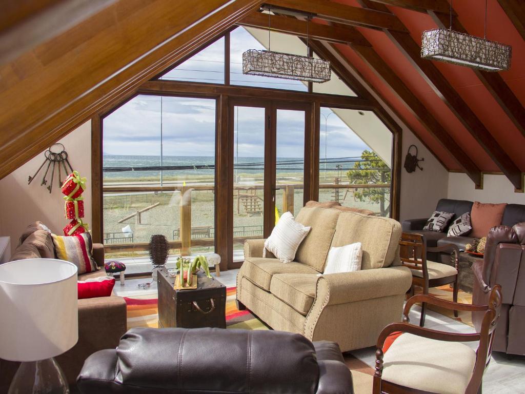 a living room filled with furniture and a large window at Hostel Entre Vientos in Punta Arenas