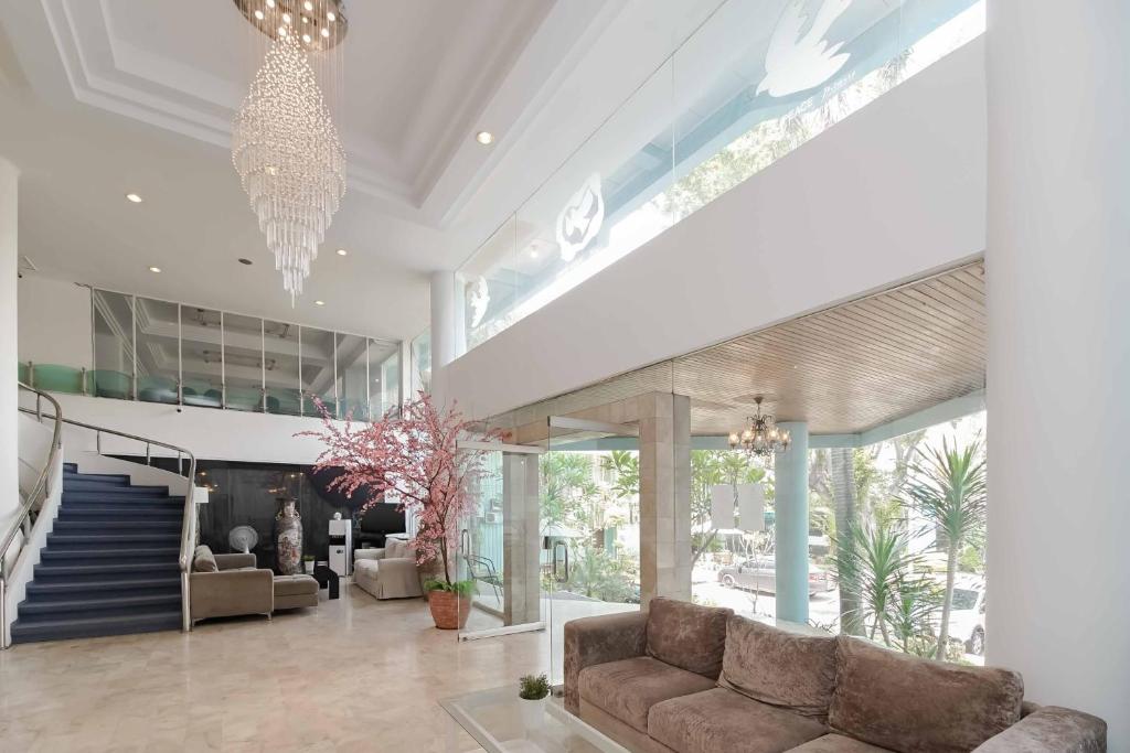 a living room with a couch and a staircase at Urbanview Hotel Kebayoran Baru Blok S in Jakarta