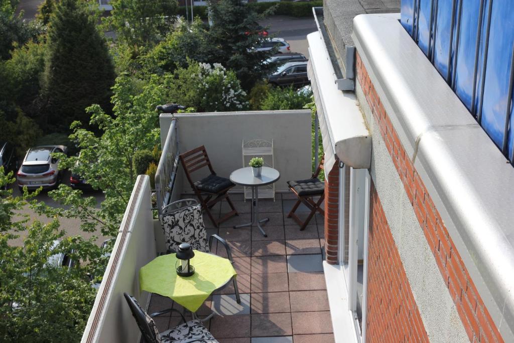 - un petit balcon avec une table et des chaises dans un bâtiment dans l'établissement FeWo Jadeblick - Horumersiel, à Horumersiel