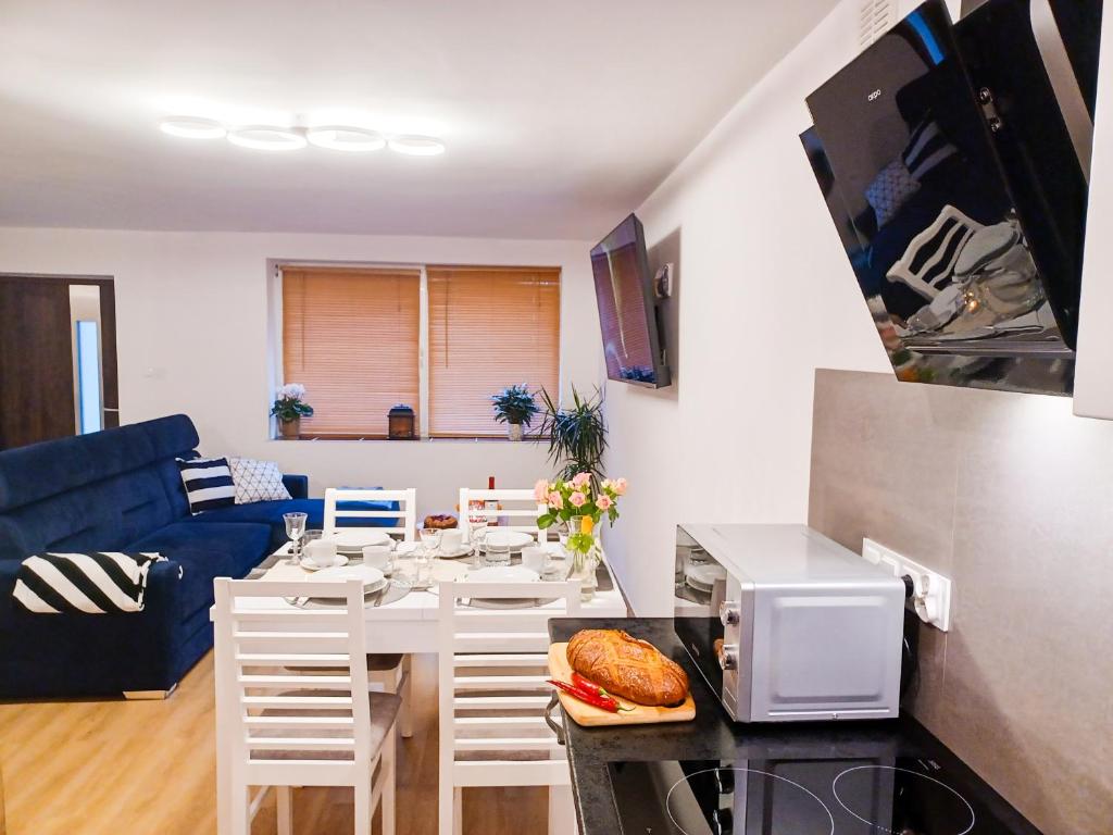 eine Küche und ein Wohnzimmer mit einem Tisch und einer Mikrowelle in der Unterkunft Apartament LABA in Sosnowka