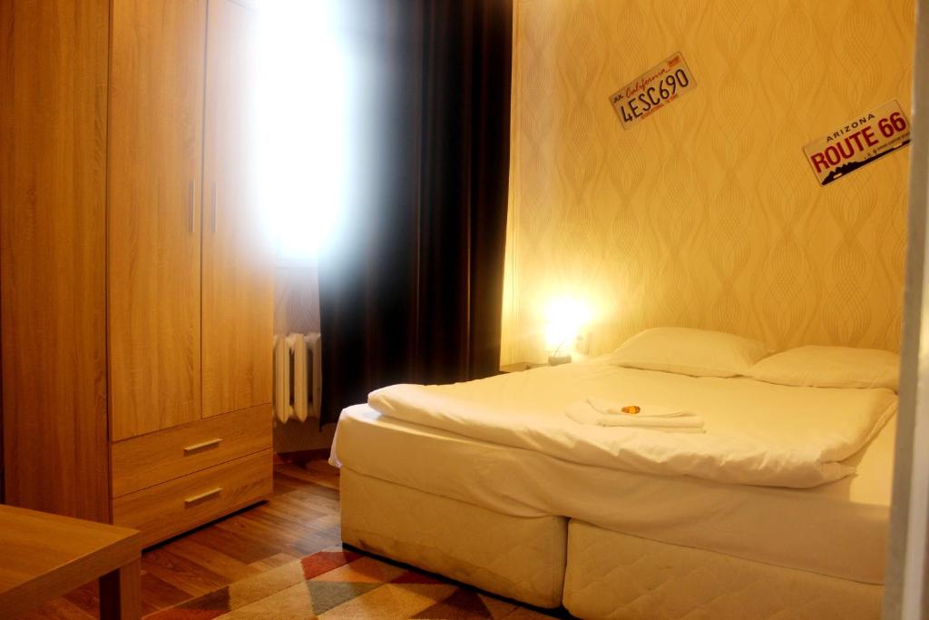 1 dormitorio con cama blanca y letreros en la pared en Hotello, en Sofía