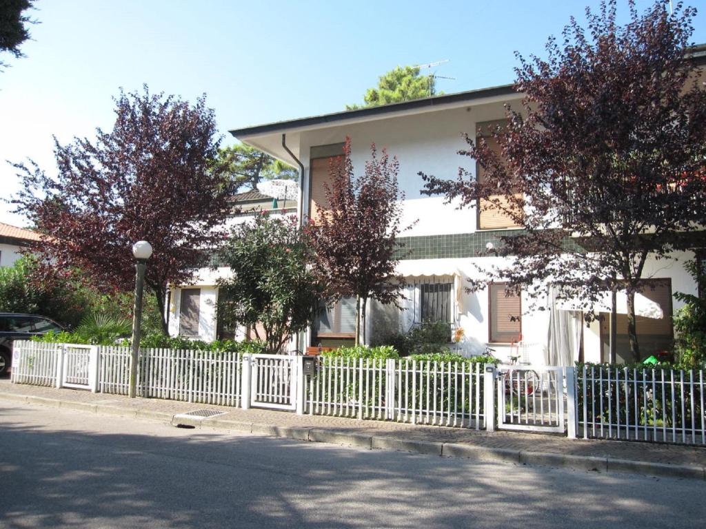 a white fence in front of a white house at Appartamento Pineta in Grado