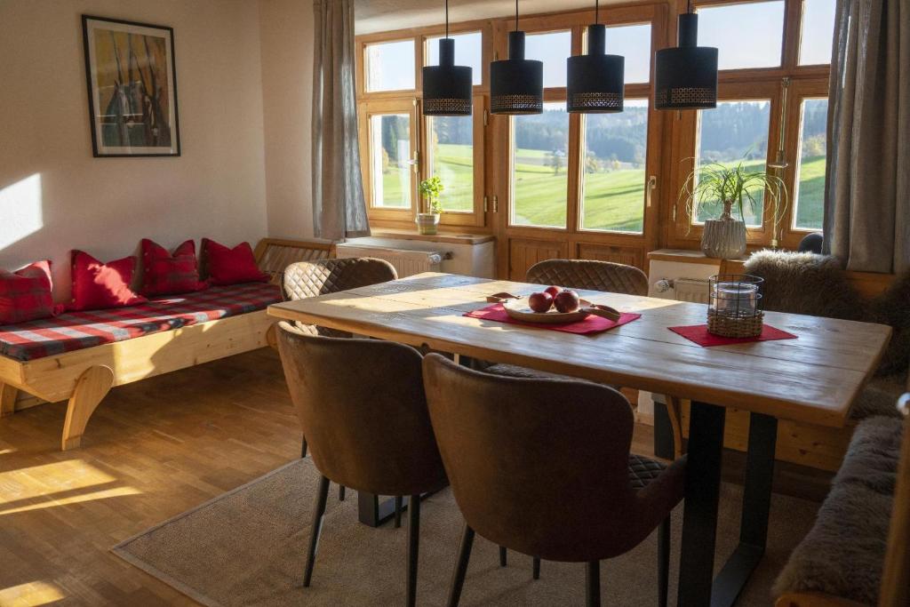 un soggiorno con tavolo, sedie e divano di Ruhe-haus a Grafenau