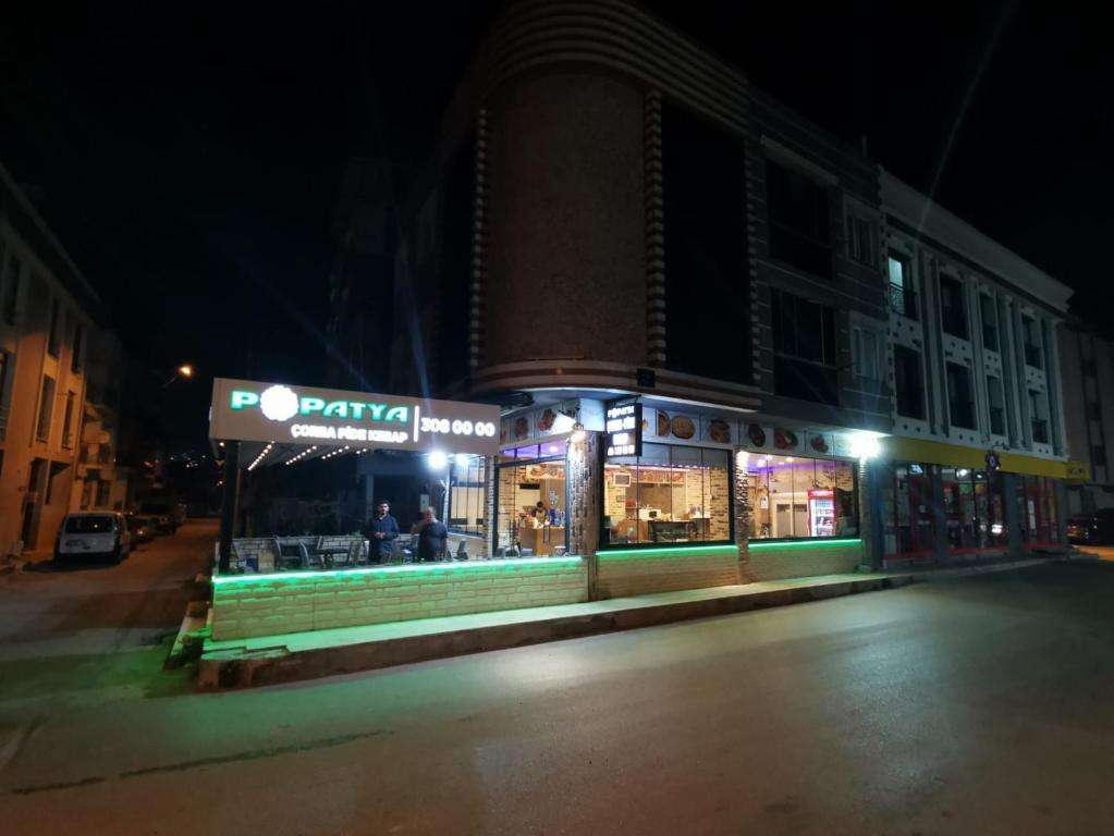 a store on the side of a street at night at Ege üniversitesi ve hastanesine çok yakın in Burunabat