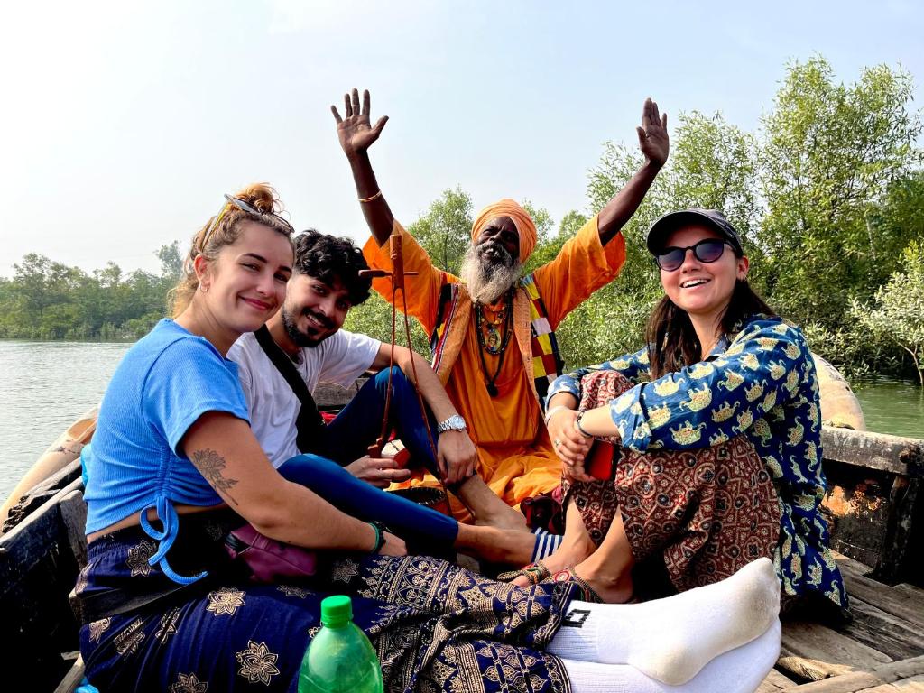 Satrangi Homestay Sundarban في Kākdwīp: مجموعة من الناس يجلسون في قارب على الماء