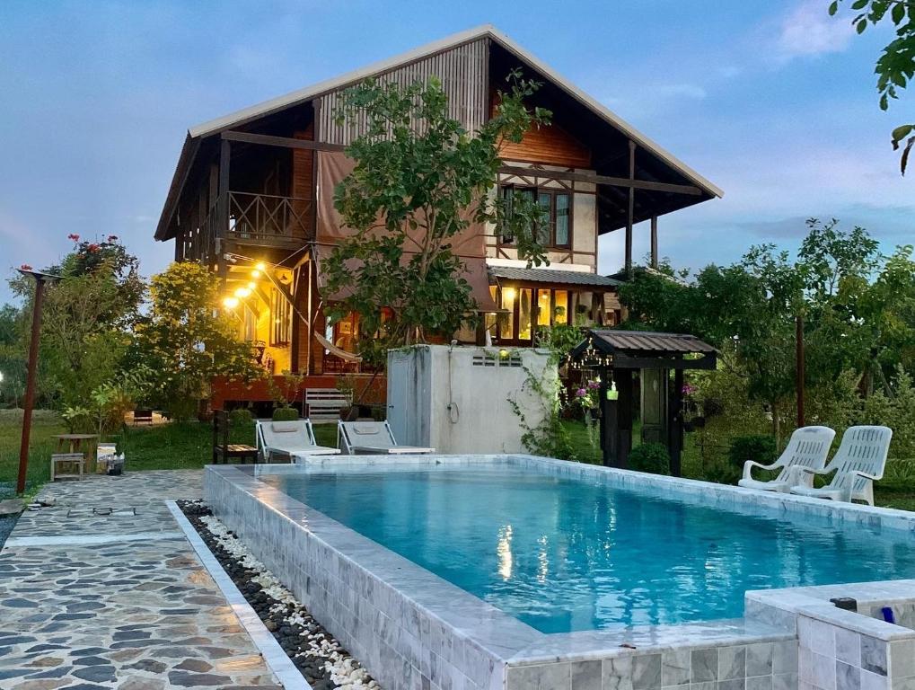 una casa con piscina frente a una casa en Rang Robin Farmstay for 4 with pool en Ban Wang Muang
