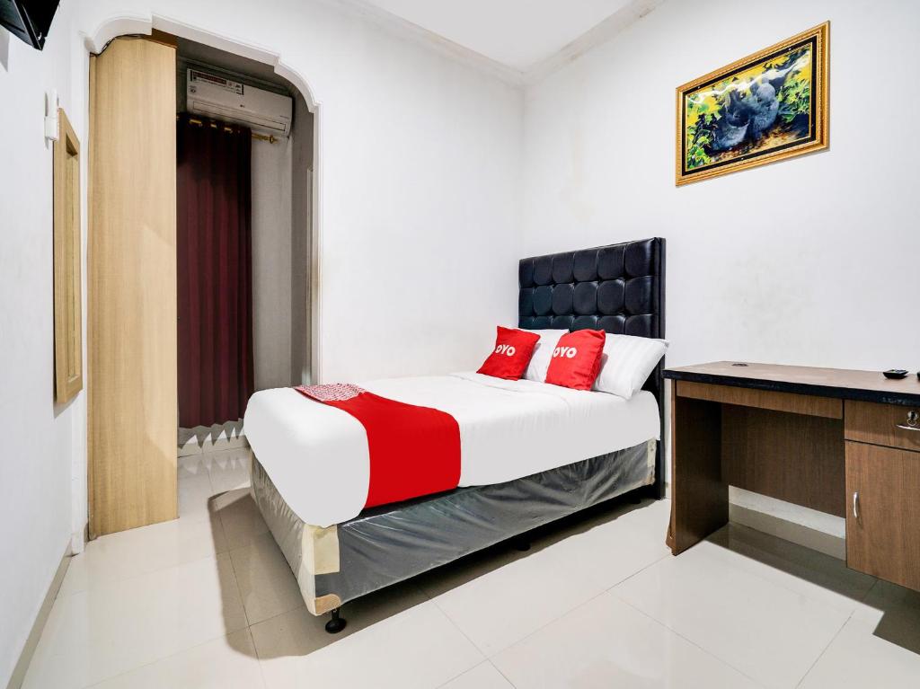 - une chambre avec un lit et un bureau dans l'établissement OYO Life 91994 Sawerigading Jatinangor Syariah, à Sayang