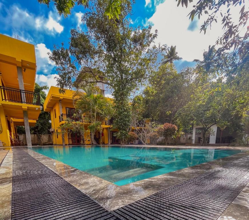 希卡杜瓦的住宿－Easy Living，黄色建筑前的游泳池