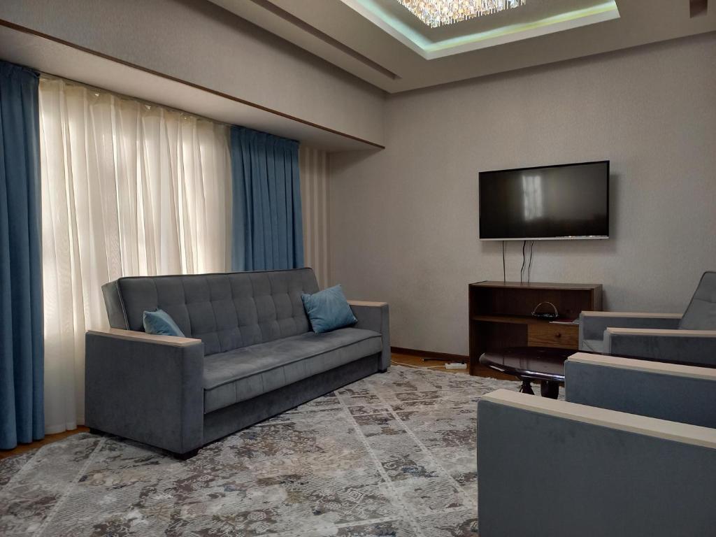 sala de estar con sofá y TV de pantalla plana en Apartment Center 1, en Tashkent
