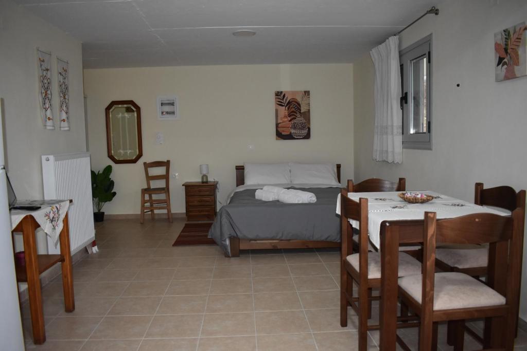1 dormitorio con 1 cama, mesa y sillas en Tzoumerka Guest House, en Rámia