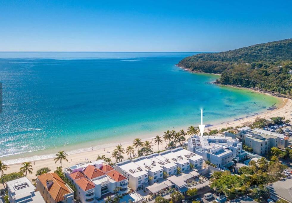 an aerial view of a beach with palm trees and buildings at 18OB Absolute Beachfront - Noosa Main Beach in Noosa Heads