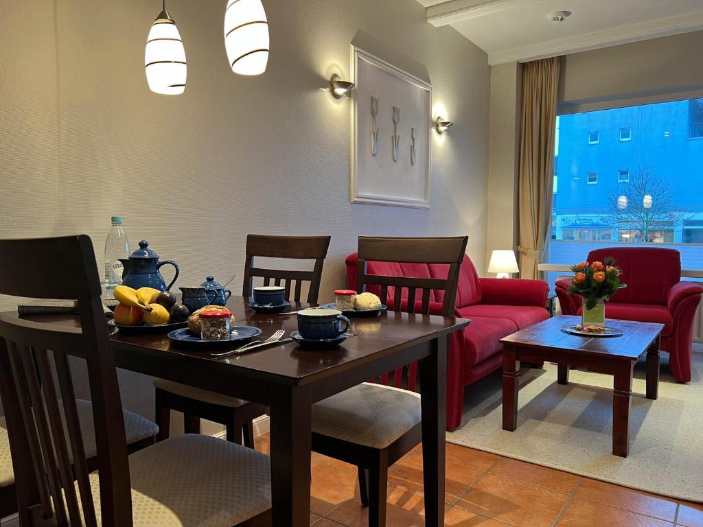 a living room with a table and a red couch at Robbe in Westerland