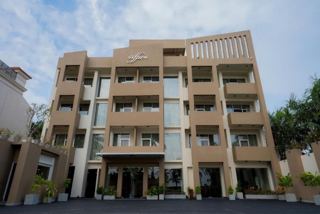 a large apartment building in front of a cloudy sky at Saffron Hotel Unawatuna in Unawatuna