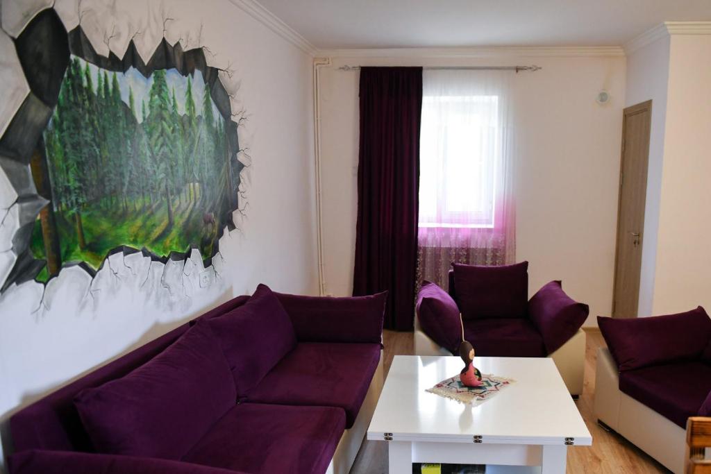 a living room with a purple couch and a table at Manana Guesthouse in Marmarik