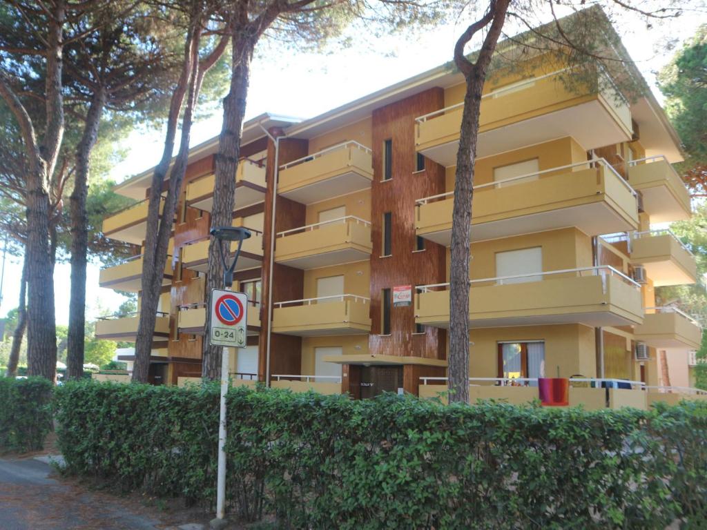 un edificio amarillo sin señal de estacionamiento delante de él en Michelangelo Beach, en Lignano Sabbiadoro