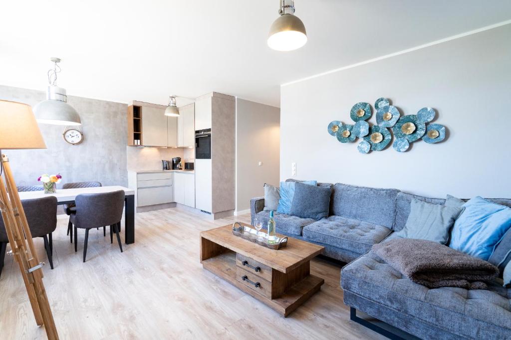 ein Wohnzimmer mit einem blauen Sofa und einem Tisch in der Unterkunft Ferienwohnung Puro in Scharbeutz