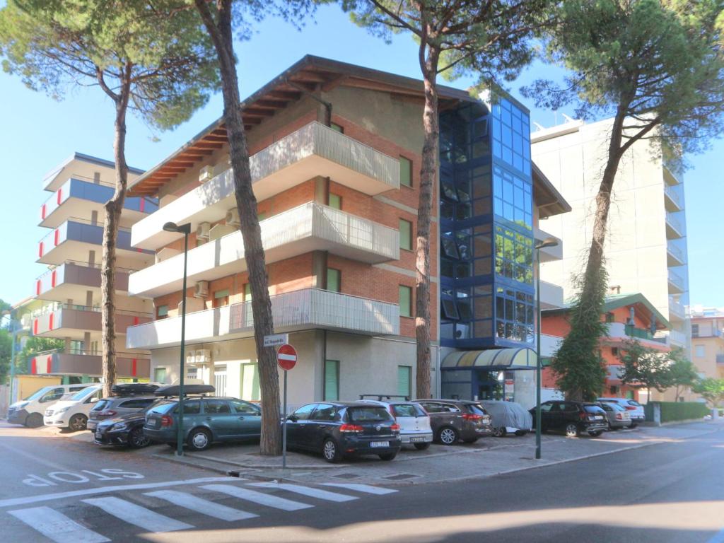un edificio con coches estacionados en un estacionamiento en Elena, en Lignano Sabbiadoro