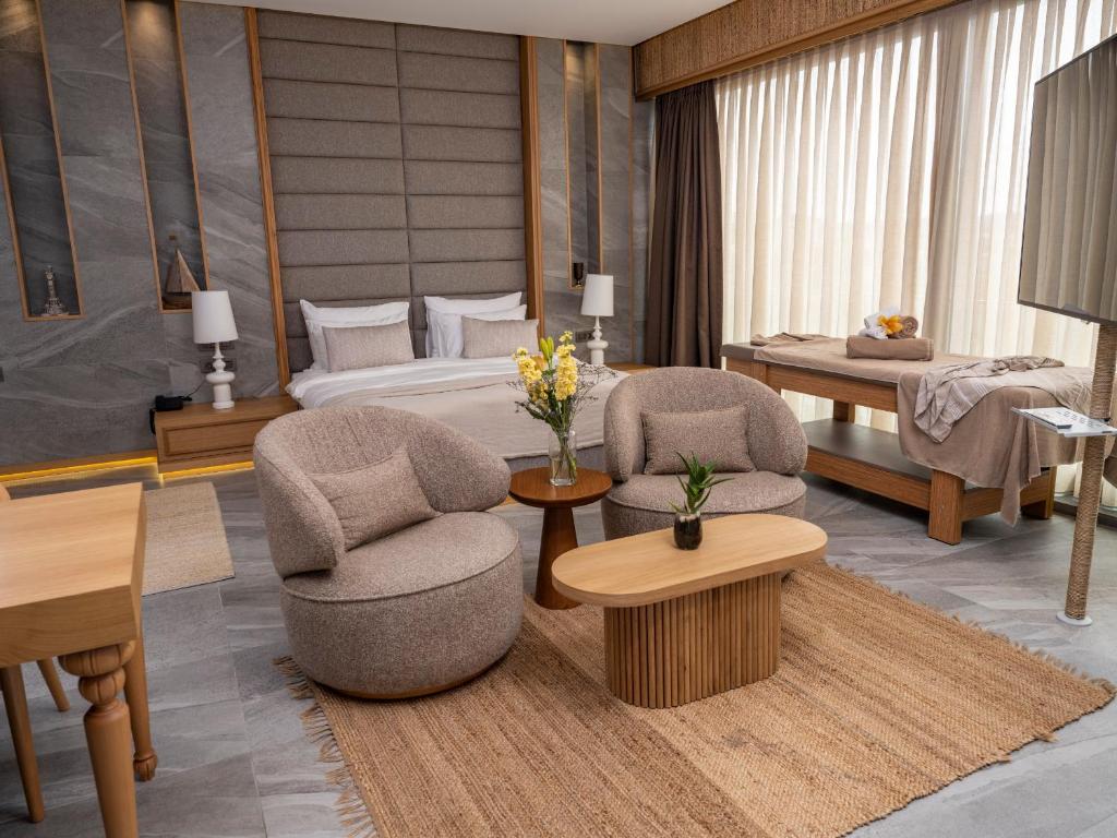a hotel room with two chairs and a bed at Sa'Rezya Hotel in Çeşme
