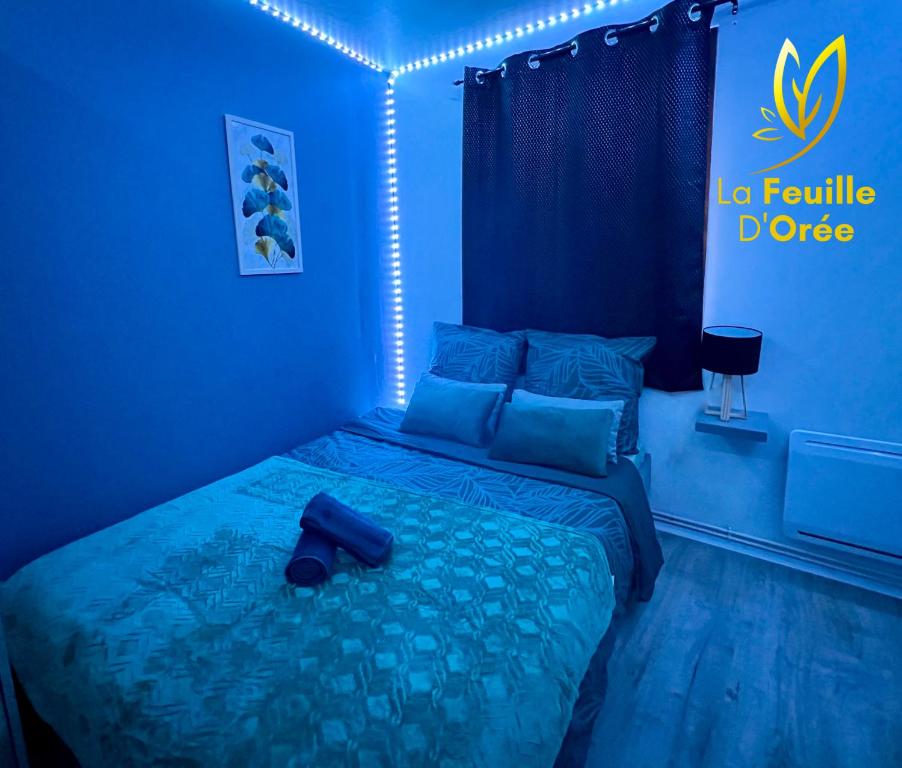 een blauwe slaapkamer met een bed en een blauw licht bij La Feuille Dorée, Hyper-Centre, 15min Rouen in Barentin