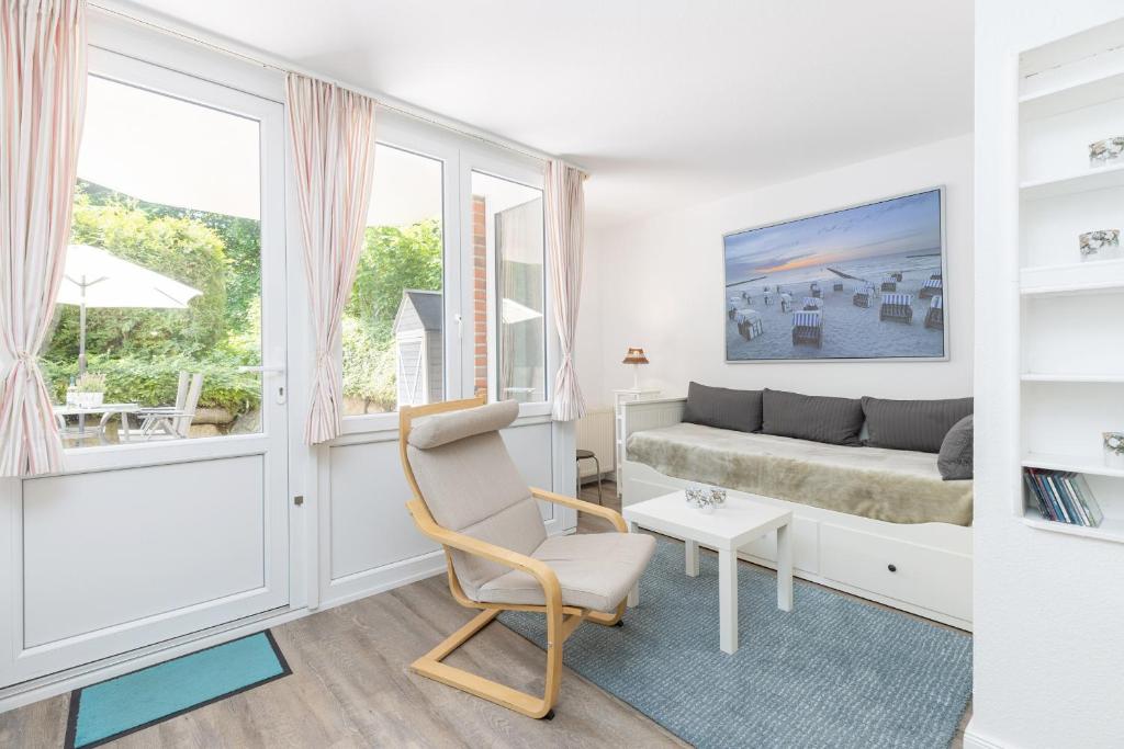 ein Wohnzimmer mit einem Sofa und einem Stuhl in der Unterkunft Ferienwohnung Die 2b in Timmendorfer Strand