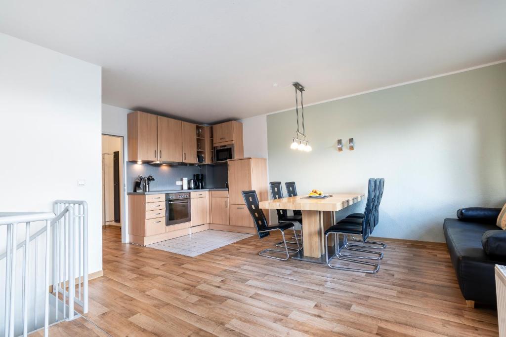 ein Wohnzimmer und eine Küche mit einem Tisch und Stühlen in der Unterkunft Ferienwohnung Sandburg App 27a in Timmendorfer Strand