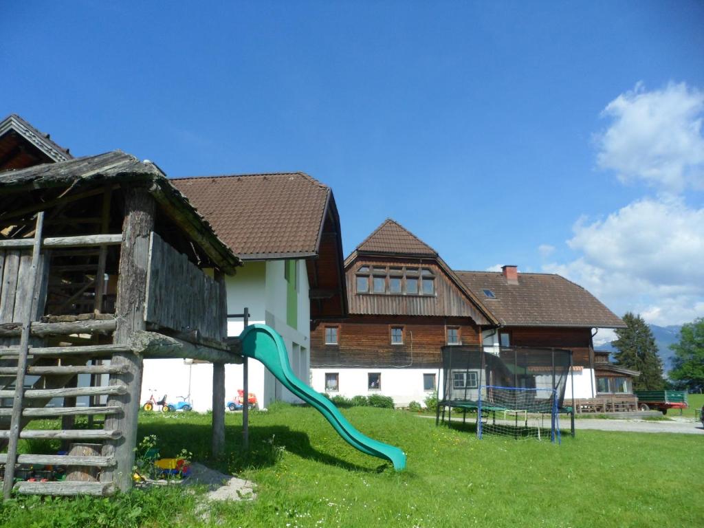 um parque infantil em frente a uma casa com escorrega em Ferienhaus 1 em Auberg