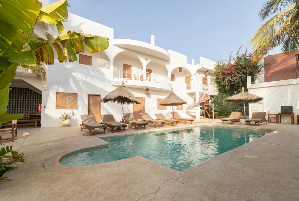 a hotel with a swimming pool in front of a building at Casa Louka in Saly Portudal