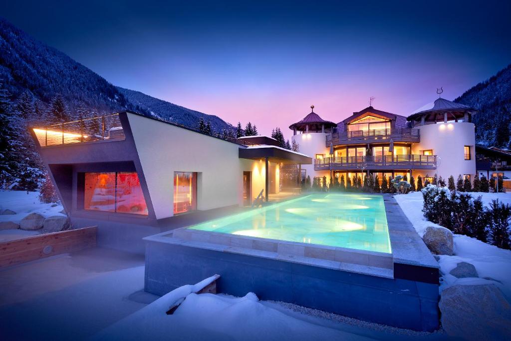 a house with a swimming pool in the snow at FONTIS luxury spa lodge in Santa Maddalena in Casies Valbassa